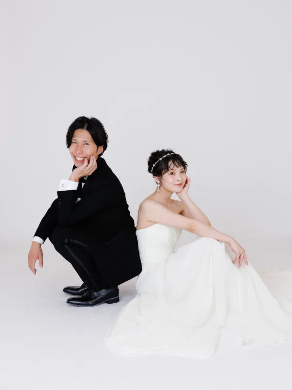 白いスタジオで、ウェディングドレスの花嫁と新郎
