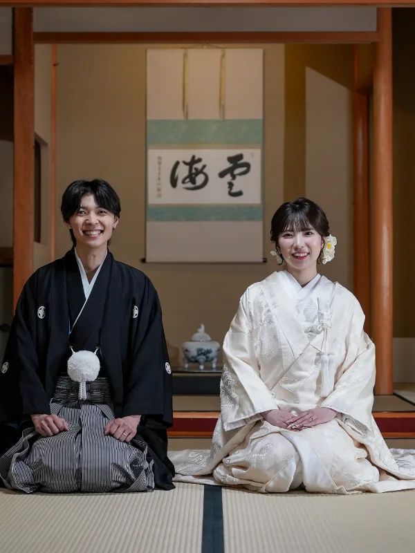 掛け軸と畳の茶室に座る、白無垢の花嫁と新郎