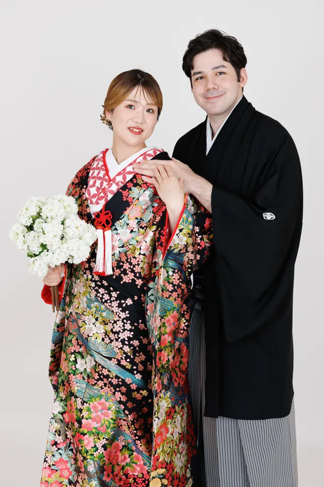 スタジオで、黒地に花の色打掛の花嫁と新郎