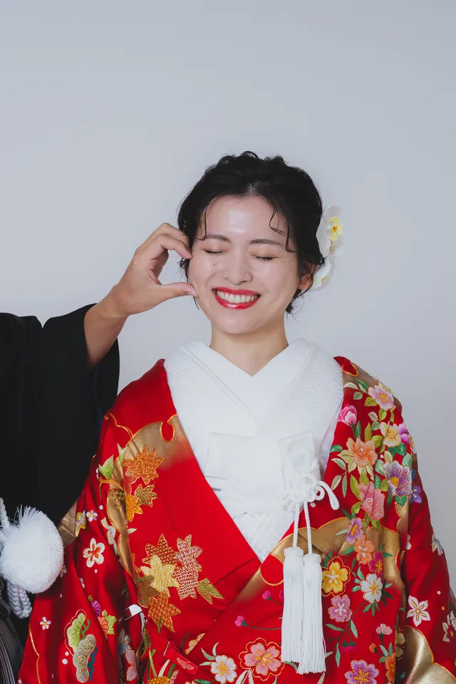 スタジオで笑う、赤い色打掛の花嫁